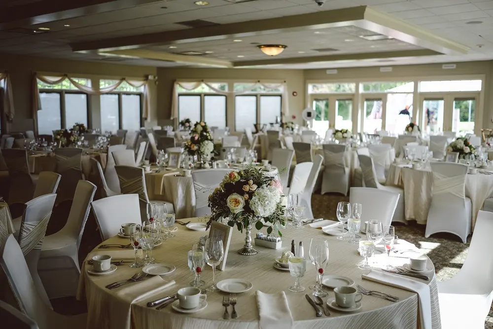The reception room set with round tables and floor-to-ceiling windows